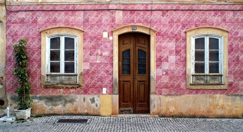 A rustic pink building in an old town in the Algarve, which are great for exploring when on an Algarve weekend break