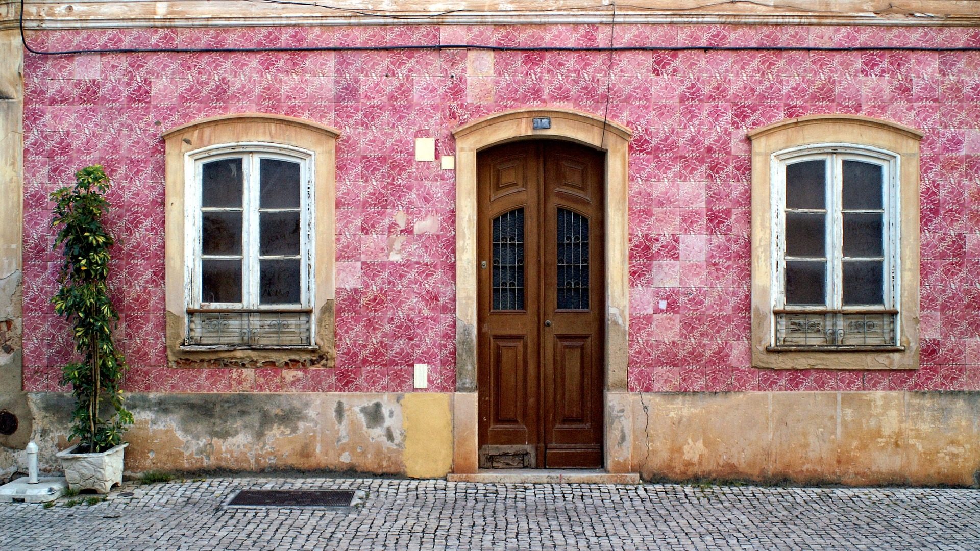 A rustic pink building in an old town in the Algarve, which are great for exploring when on an Algarve weekend break